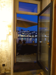 Boats on the Douro river and Vila Nova de Gaia with the Avenida de Diogo Leite street, viewed through the entrance to the Muro do Bacalhau restaurant, at sunset