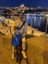 Miaomiao and Max at the Cais da Estiva street, with a view on the Ponte Luís I bridge over the Douro river and Vila Nova de Gaia with the Mosteiro da Serra do Pilar monastery, by night