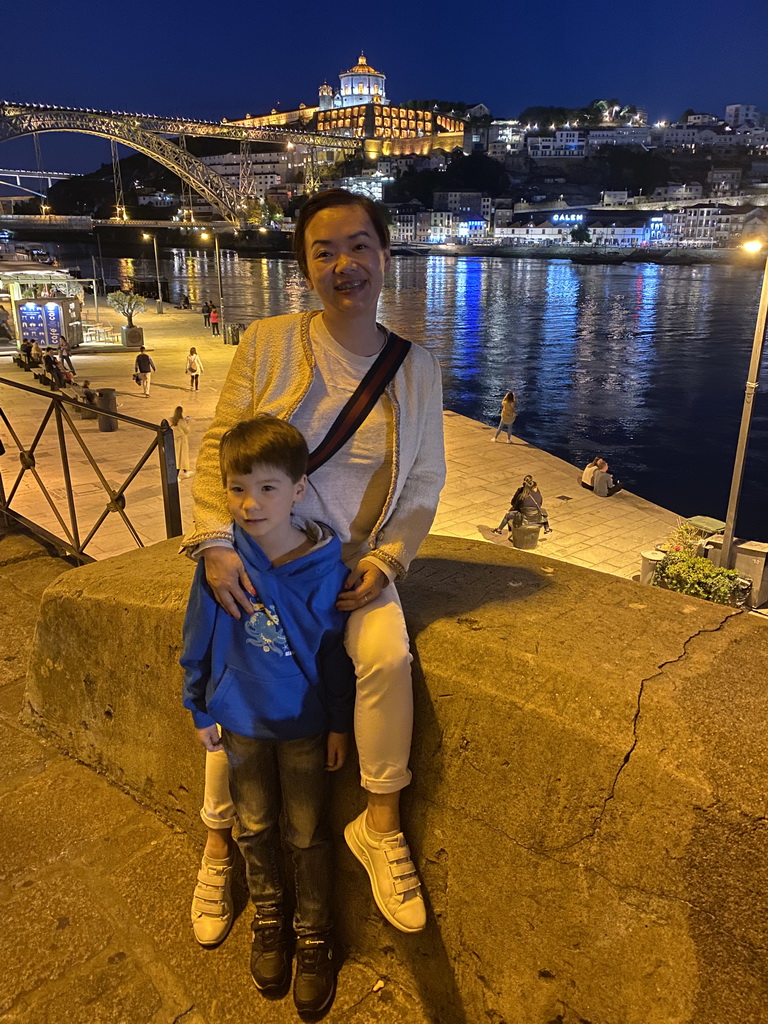 Miaomiao and Max at the Cais da Estiva street, with a view on the Ponte Luís I bridge over the Douro river and Vila Nova de Gaia with the Mosteiro da Serra do Pilar monastery, by night