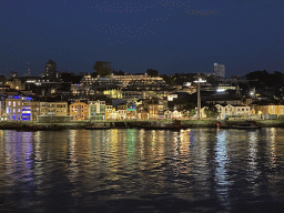 Boats on the Douro river and Vila Nova de Gaia with the Avenida de Diogo Leite street, viewed from the Cais da Estiva street, by night