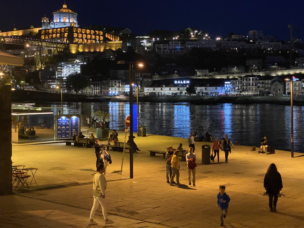 Miaomiao and Max at the Cais da Estiva street, with a view on the Ponte Luís I bridge over the Douro river and Vila Nova de Gaia with the Mosteiro da Serra do Pilar monastery, by night