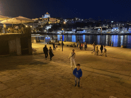 Miaomiao and Max at the Cais da Estiva street, with a view on the Ponte Luís I bridge over the Douro river and Vila Nova de Gaia with the Mosteiro da Serra do Pilar monastery, by night