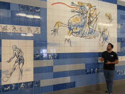 Our tour guide with painted tiles on the wall of the parking lot of the Estádio do Dragão stadium