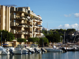 Boats in the south side of the harbour and an apartment building at the Carrer del Verí street, viewed from the Passeig des Cap des Toll street