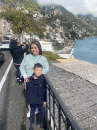 Miaomiao and Max next to the roof of the Il Capitano restaurant at the Viale Pasitea street, with a view on the town center, the Positano Spiaggia beach and the Tyrrhenian Sea