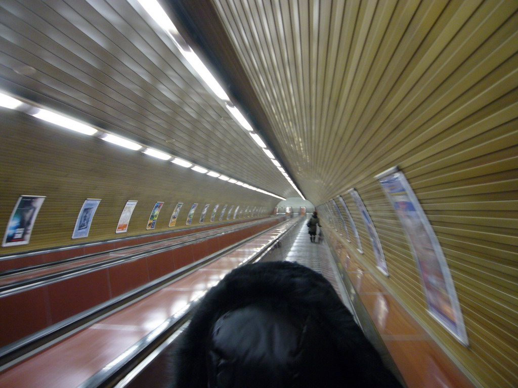 Miaomiao on a long escalator in a metro station