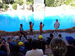 Zookeepers with Blue-and-yellow Macaws at the Dolphinarium at the Loro Parque zoo, just before the Dolphin show