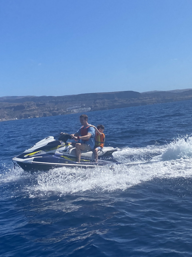 Tim and Max on a jet ski in front of the coastline