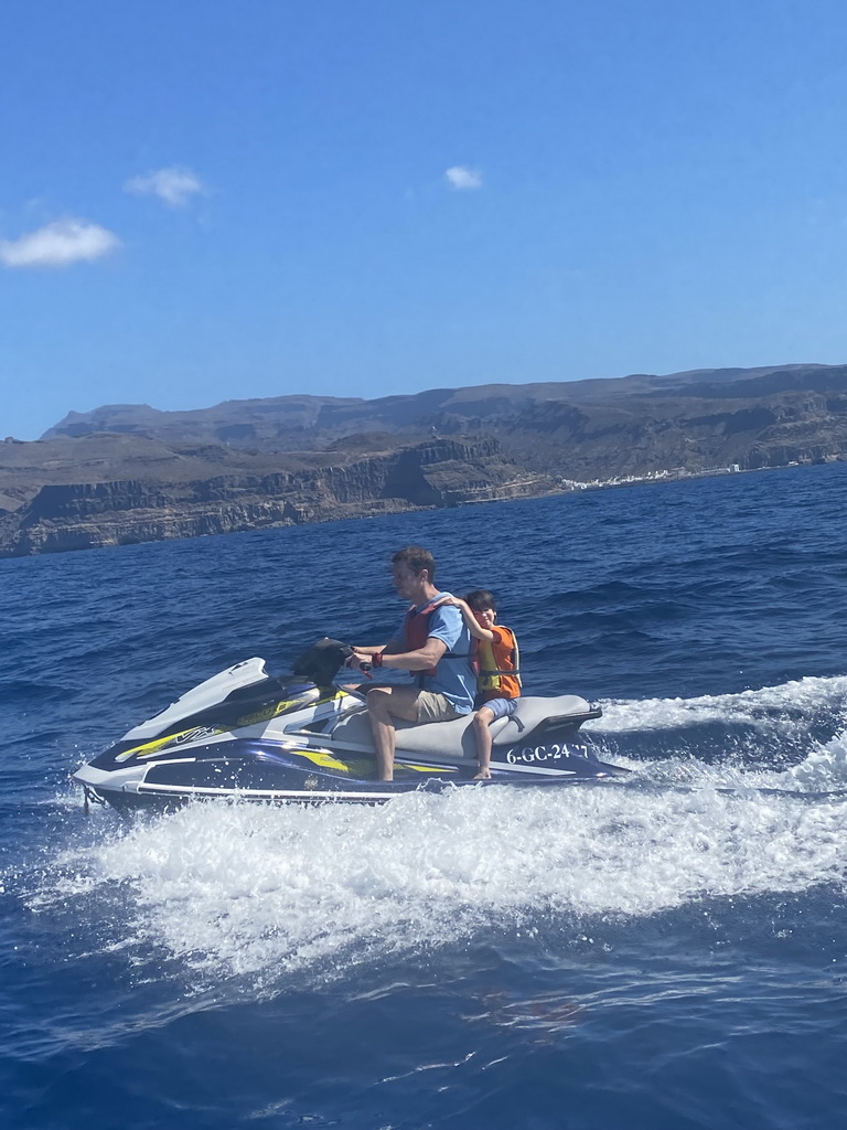 Tim and Max on a jet ski in front of the coastline