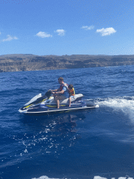 Tim and Max on a jet ski in front of the coastline