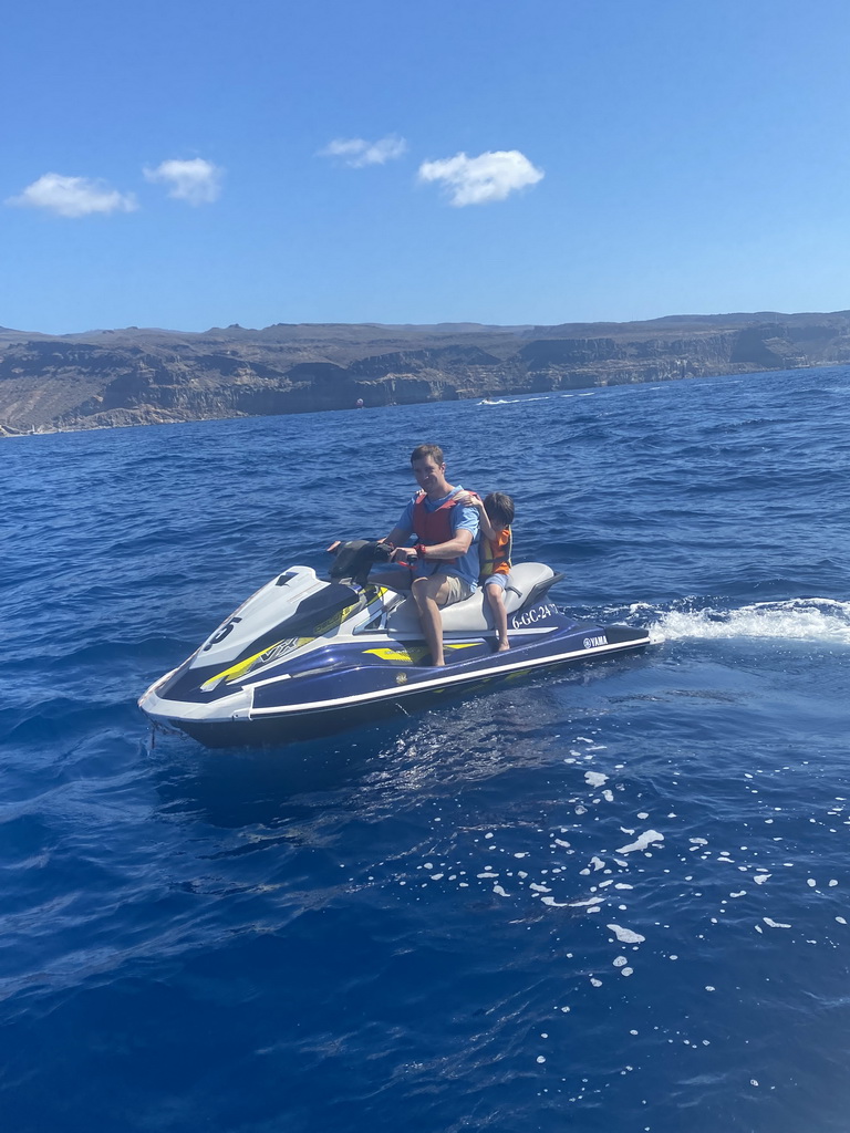 Tim and Max on a jet ski in front of the coastline