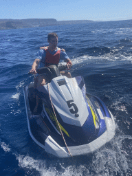 Tim and Max on a jet ski in front of the coastline