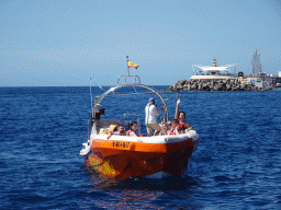 Miaomiao on the small boat from the parasail to the Sagitarius Cat boat, in front of the town center with the pavilion of Beach Club Faro and the harbour, viewed from the Sagitarius Cat boat