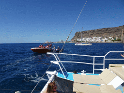 Miaomiao on the small boat from the parasail to the Sagitarius Cat boat, in front of the town center with the harbour and the Hotel THe Puerto de Mogán, viewed from the Sagitarius Cat boat