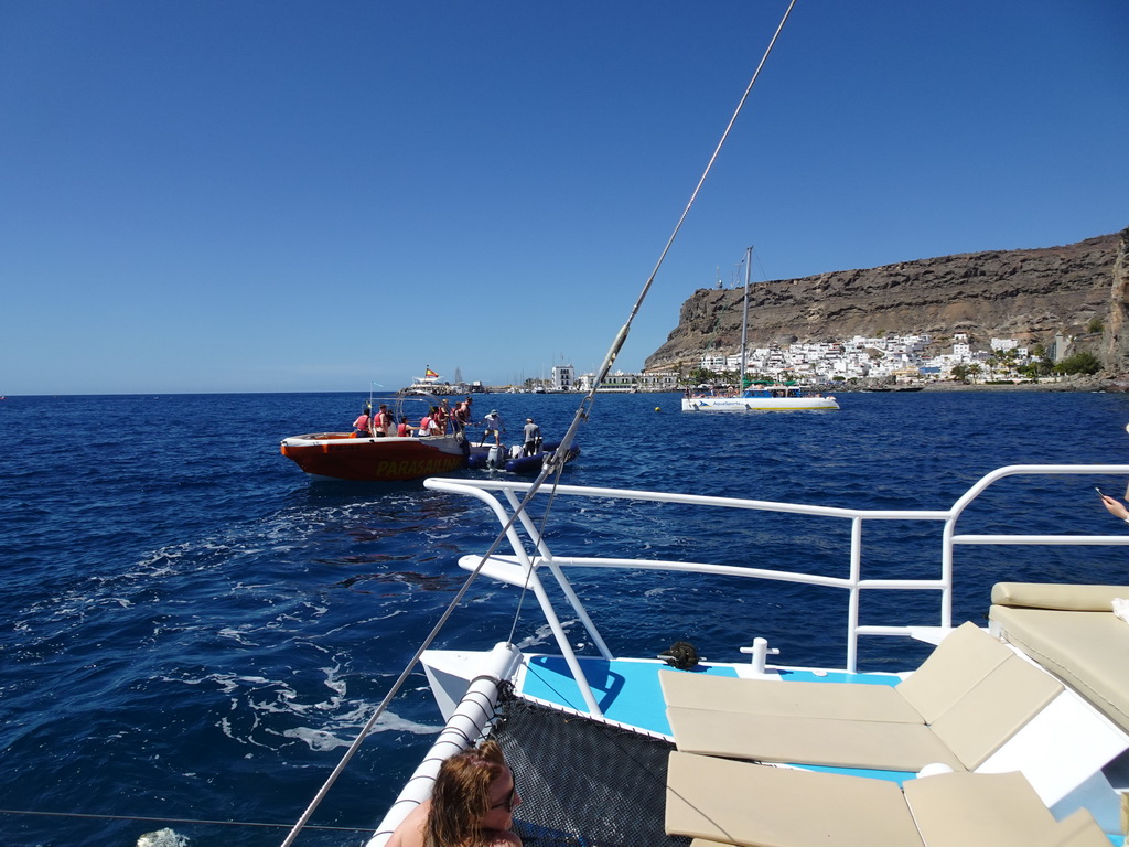 Miaomiao on the small boat from the parasail to the Sagitarius Cat boat, in front of the town center with the harbour and the Hotel THe Puerto de Mogán, viewed from the Sagitarius Cat boat