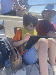 Miaomiao and Max playing with iPad on the deck of the Sagitarius Cat boat