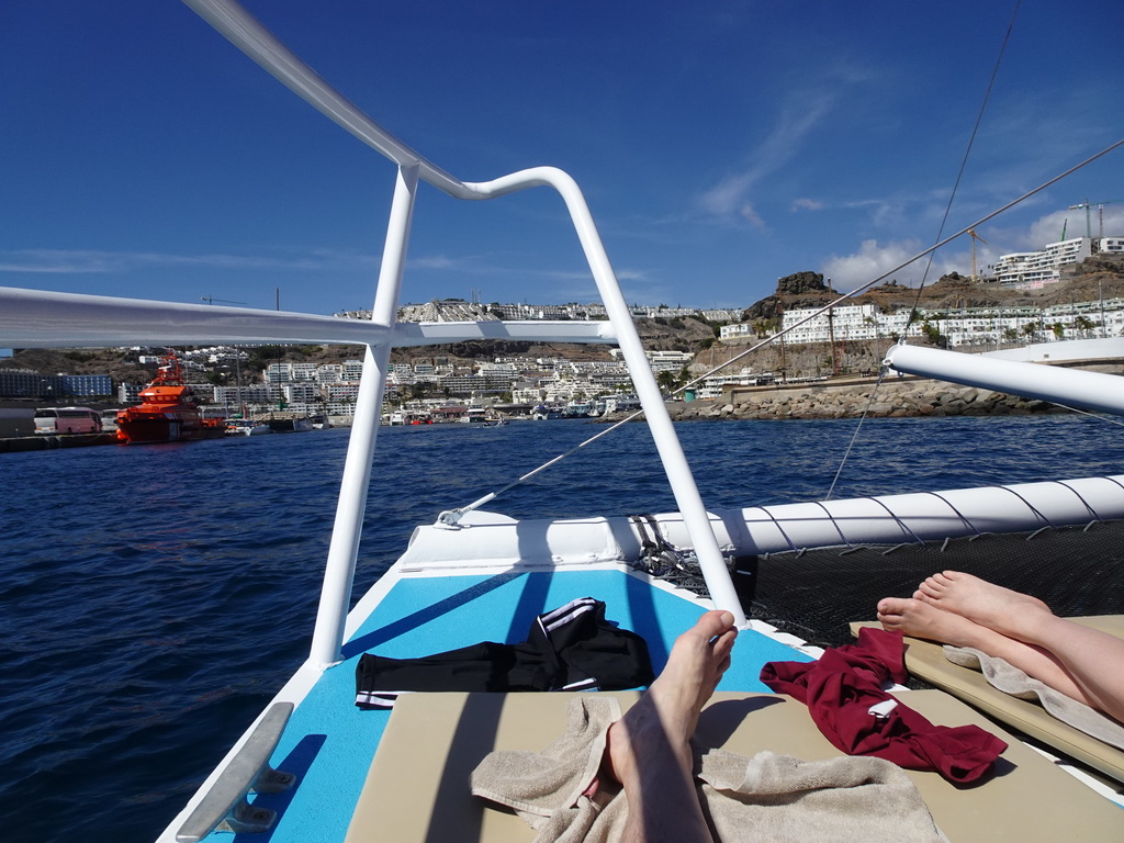 Tim and Miaomiao on the deck of the Sagitarius Cat boat, with a view on the harbour