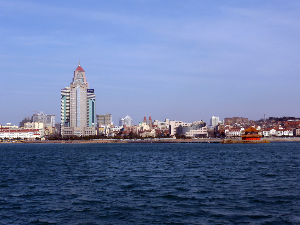 Qingdao Bay, Zhan Qiao pier, the beach at Taiping Road, skyscrapers at the city center and St. Michael`s Cathedral, viewed from the tour boat