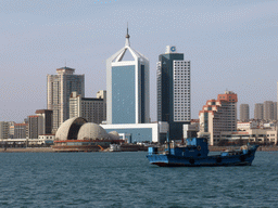 Boat in Qingdao Bay and skyscrapers and dome at the west side of the city, viewed from the tour boat