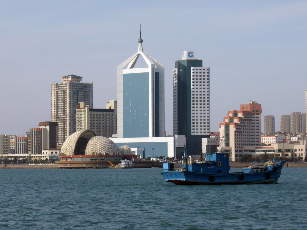 Boat in Qingdao Bay and skyscrapers and dome at the west side of the city, viewed from the tour boat
