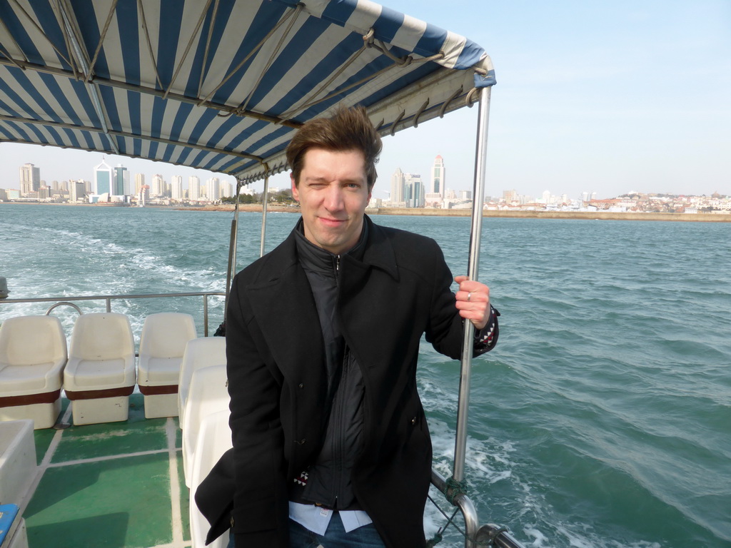 Tim on the tour boat, with a view on Qingdao Bay and skyscrapers at the city center