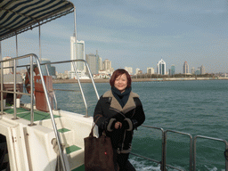 Miaomiao on the tour boat, with a view on Qingdao Bay and skyscrapers at the west side of the city and the city center