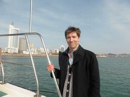 Tim on the tour boat, with a view on Qingdao Bay and skyscrapers at the west side of the city