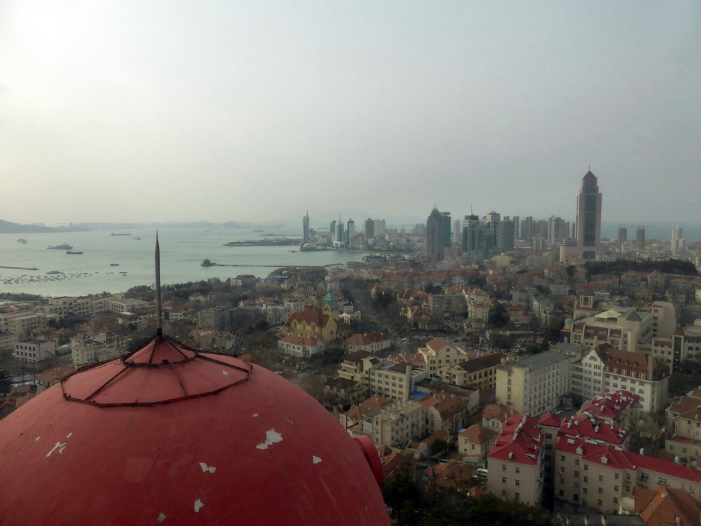 The city center with skyscrapers and the Qingdao Protestant Church, Qingdao Bay with the Zhan Qiao Pier and the skyscrapers and dome at the west side of the city, viewed from the rotating sightseeing tower at the Xinhaoshan Park