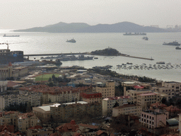 The city center with the Qingdao Naval Museum, Qingdao Bay with Xiao Qingdao island and the Huangdao district, viewed from the rotating sightseeing tower at the Xinhaoshan Park