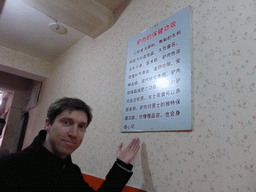 Tim with a sign in a donkey meat restaurant at Hubei Road