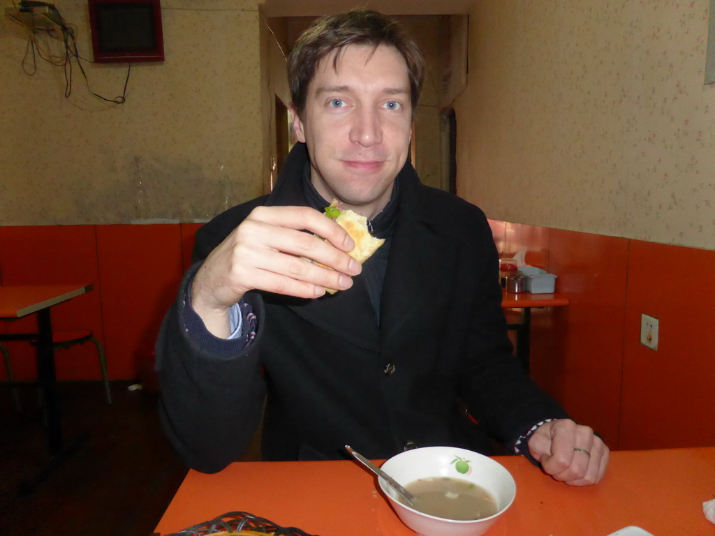 Tim with a donkey meat sandwich in a donkey meat restaurant at Hubei Road
