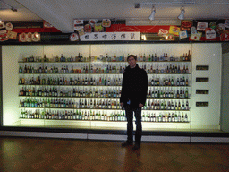 Tim with beer cans and bottles from various brands, at the Tsingtao Beer Museum