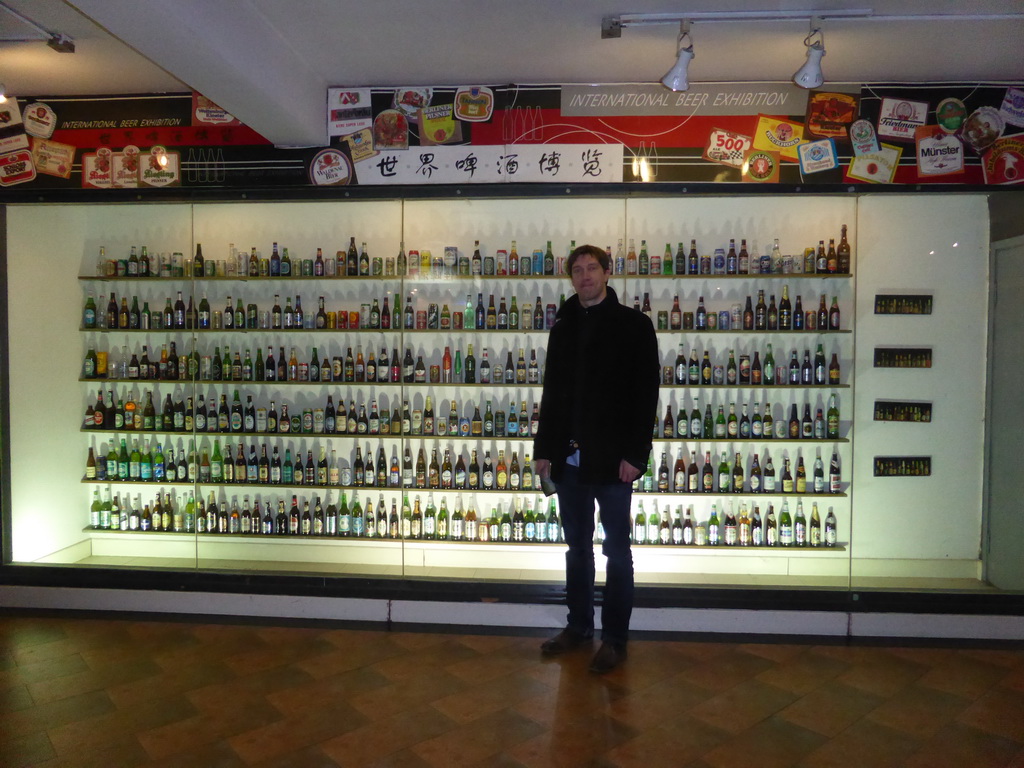 Tim with beer cans and bottles from various brands, at the Tsingtao Beer Museum