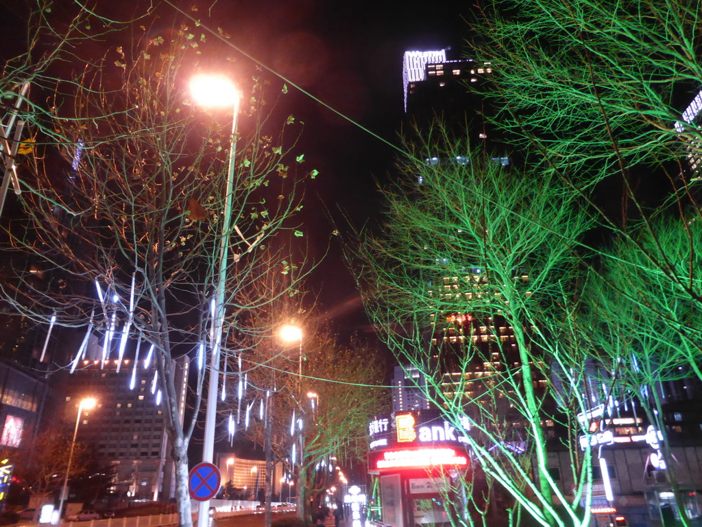 Trees with decorations and World Trade Center buildings at Xianggang Middle Road, by night