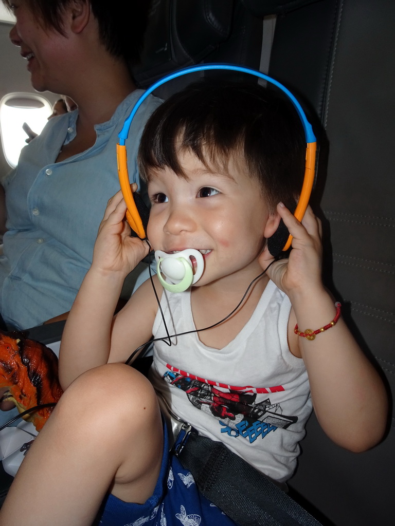 Max with headphones in the airplane from Amsterdam