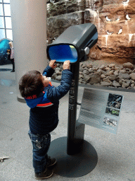 Max with a telescope in front of the model of the Látrabjarg Cliff at the Wonders of Iceland exhibition at the Ground Floor of the Perlan building