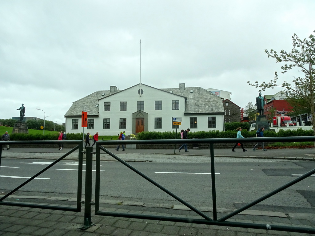 The Lækjargata street with the front of the Stjórnarráðið Government House and the statues of King Christian IX of Denmark and Hannes Hafstein, viewed from the rental car