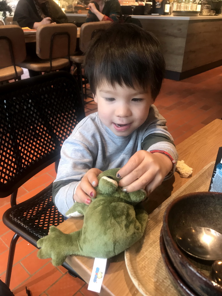 Max with a frog toy having lunch at the restaurant at the Visitor Center Veluwezoom