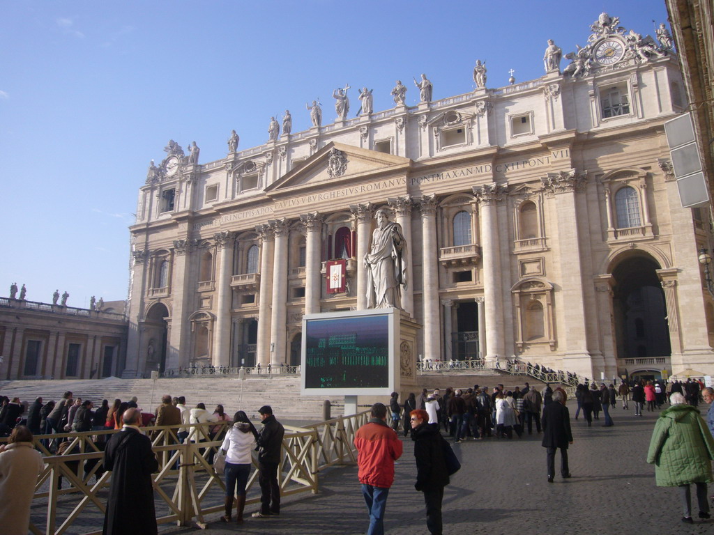 The facade of St. Peter`s Basilica, with the Pope`s Window, the Statue of St. Paul and a big television screen