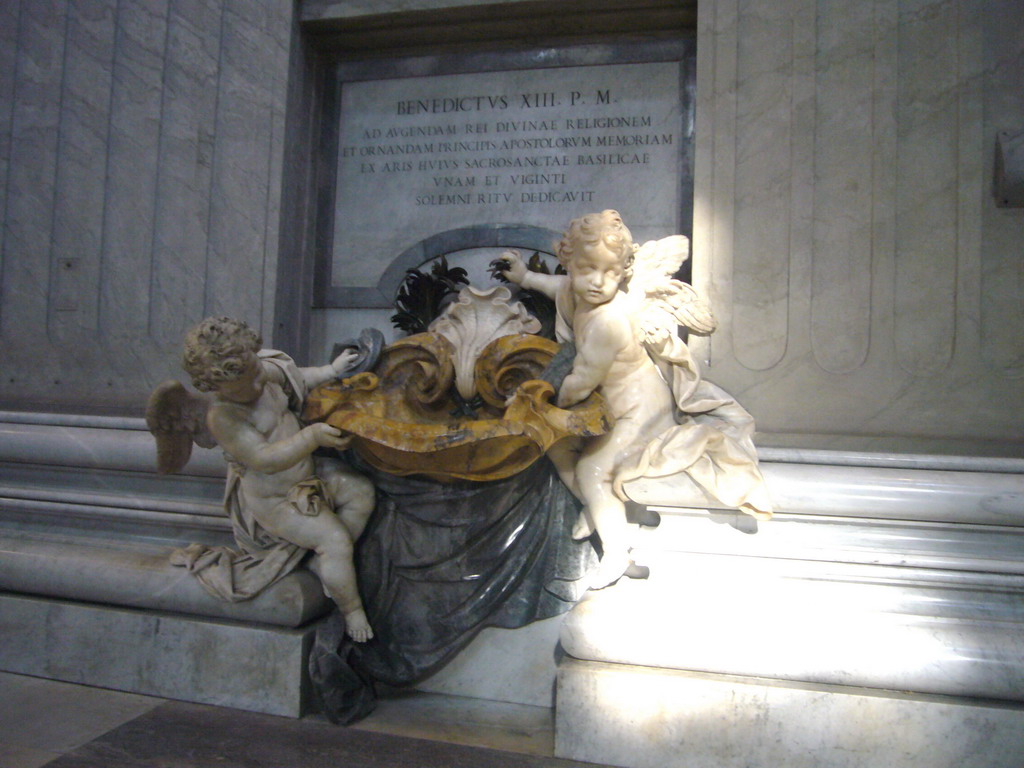 Statues of Cupidos offering holy water, at the foot of the Monument of Pope Benedict XIII, inside St. Peter`s Basilica