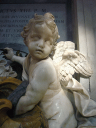 Statue of a Cupido offering holy water, at the foot of the Monument of Pope Benedict XIII, inside St. Peter`s Basilica