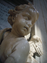 Statue of a Cupido offering holy water, at the foot of the Monument of Pope Benedict XIII, inside St. Peter`s Basilica