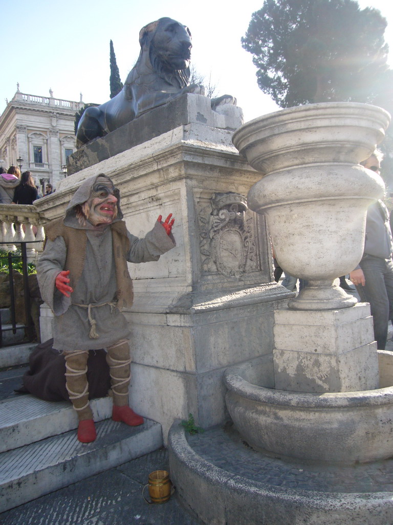 Statue of an Egyptian Lion at the foot of the Capitoline Hill, with a street artist