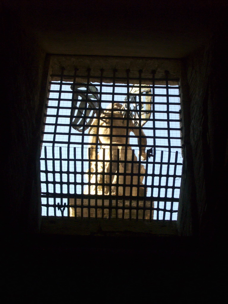 The back side of the marble statue of Saint Michael at the Castel Sant`Angelo, through a window
