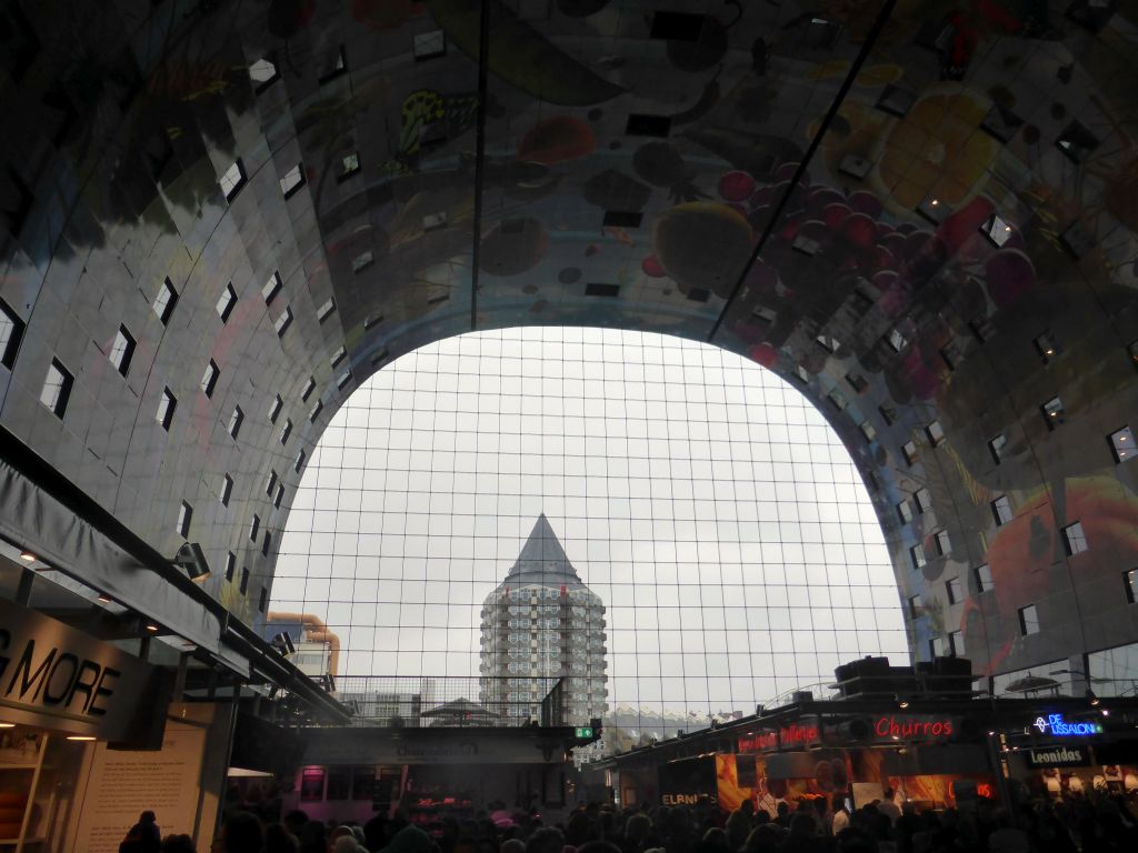 The Markthal building with its ceiling and market stalls, with a view on the Blaaktoren tower