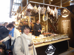 Miaomiao in front of a market stall with meat in the Markthal building