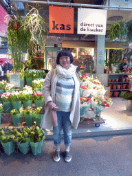 Miaomiao in front of a market stall with flowers in the Markthal building