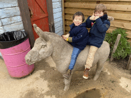 Max and his friend on top of a donkey statue in front of the chip twister restaurant at the South America area at the Diergaarde Blijdorp zoo