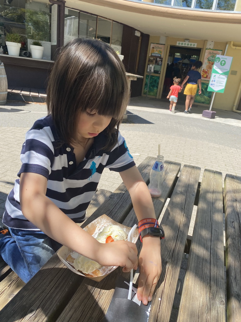 Max eating a waffle at the terrace of the restaurant of the Biotopia playground in the Rivièrahal building at the Africa area at the Diergaarde Blijdorp zoo