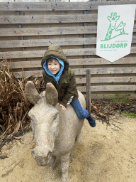 Max on top of a donkey statue in front of the chip twister restaurant at the South America area at the Diergaarde Blijdorp zoo